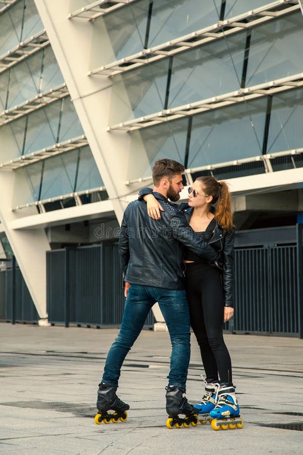 Het mooie paar die van de rolschaatser met hipsterstijl na de regen schaatsen royalty-vrije stock fotografie Het mooie paar die van de rolschaatser met hipsterstijl na de regen schaatsen royalty-vrije stock fotografie