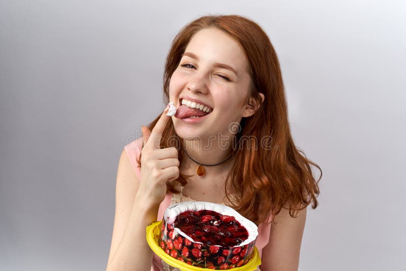 Het mooie roodharige jonge zoete meisje houdt snoepjes van cakes en gebakjeroom Zij houdt de cake royalty-vrije stock foto Het mooie roodharige jonge zoete meisje houdt snoepjes van cakes en gebakjeroom Zij houdt de cake royalty-vrije stock foto