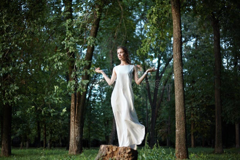 Het mooie Vrouw Stellen als Godin in Witte Lange Kleding bij Aard Bohostijl, Zielrust, Wellness Vrijheid en het Ontspannen royalty-vrije stock foto's Het mooie Vrouw Stellen als Godin in Witte Lange Kleding bij Aard Bohostijl, Zielrust, Wellness Vrijheid en het Ontspannen royalty-vrije stock foto's