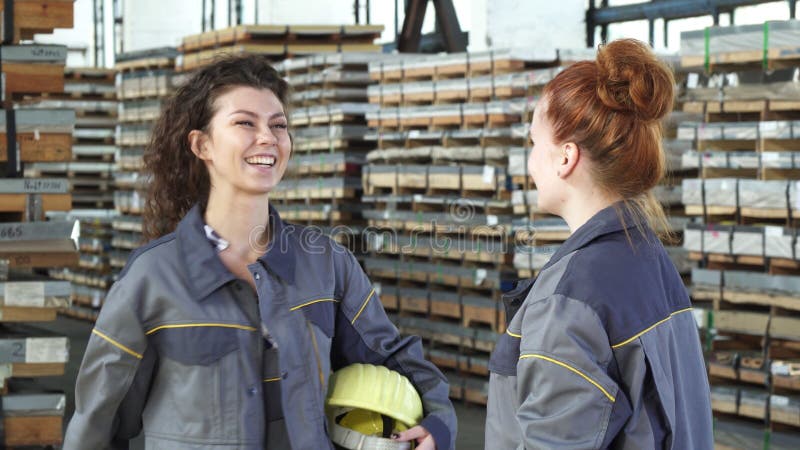 Het mooie vrouwelijke fabrieksarbeider hoge fiving met haar collega stock foto Het mooie vrouwelijke fabrieksarbeider hoge fiving met haar collega stock foto