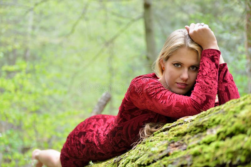 Het mooie vrouwelijke model stellen op mos behandeld logboek royalty-vrije stock fotografie Het mooie vrouwelijke model stellen op mos behandeld logboek royalty-vrije stock fotografie