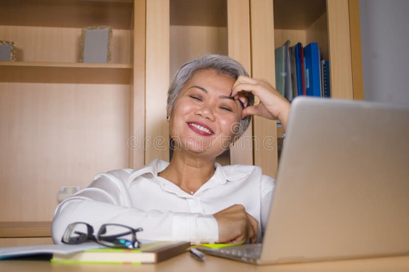 Het natuurlijke portret van het levensstijlbureau van het aantrekkelijke en gelukkige succesvolle rijpe Aziatische vrouw werken b royalty-vrije stock foto Het natuurlijke portret van het levensstijlbureau van het aantrekkelijke en gelukkige succesvolle rijpe Aziatische vrouw werken b royalty-vrije stock foto