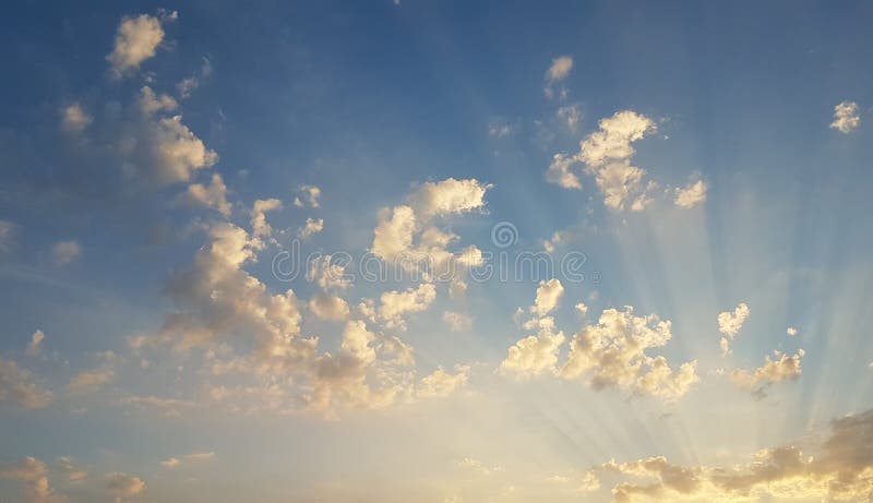In het nauw gedreven zonstralen wat betreft kleine wolken royalty-vrije stock foto In het nauw gedreven zonstralen wat betreft kleine wolken royalty-vrije stock foto