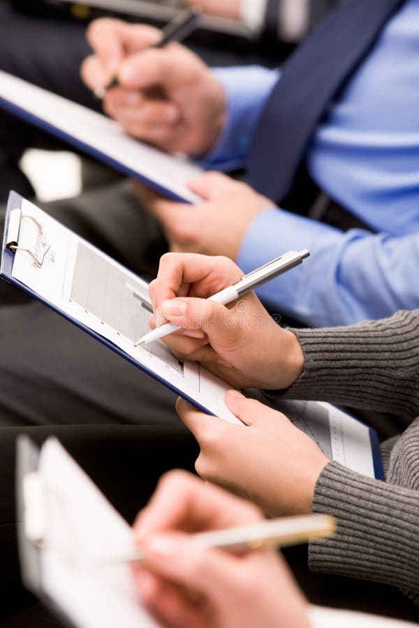 Close-up of human hands with pens over business documents. Close-up of human hands with pens over business documents