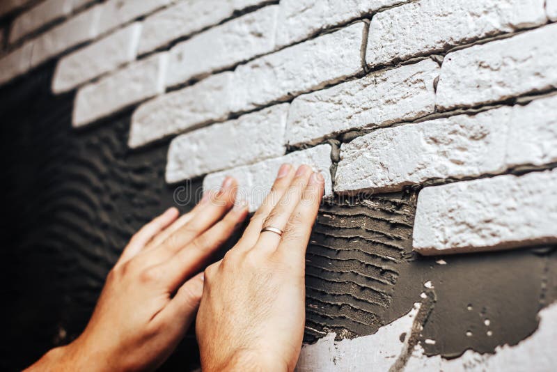 Het onder ogen zien van muur decoratieve tegels, arbeiders die bakstenen muur maken stock afbeelding Het onder ogen zien van muur decoratieve tegels, arbeiders die bakstenen muur maken stock afbeelding