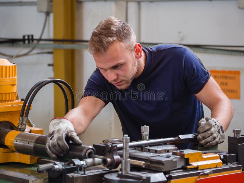 Het onderhoudswerk aangaande een buigende machine in een workshop royalty-vrije stock afbeelding Het onderhoudswerk aangaande een buigende machine in een workshop royalty-vrije stock afbeelding