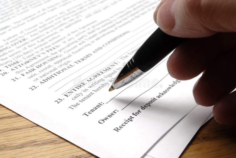 Hand holding pen signing a purchase contract or agreement. Hand holding pen signing a purchase contract or agreement