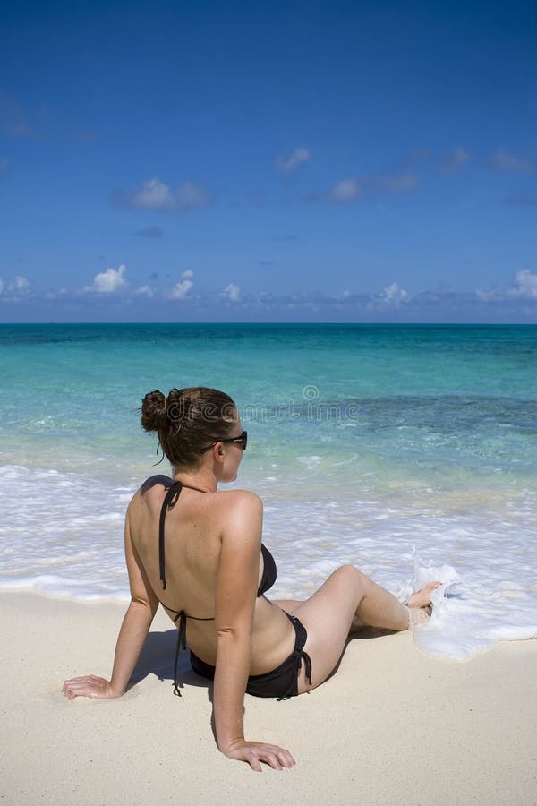 Young female relaxing on a tropical beach. Young female relaxing on a tropical beach.