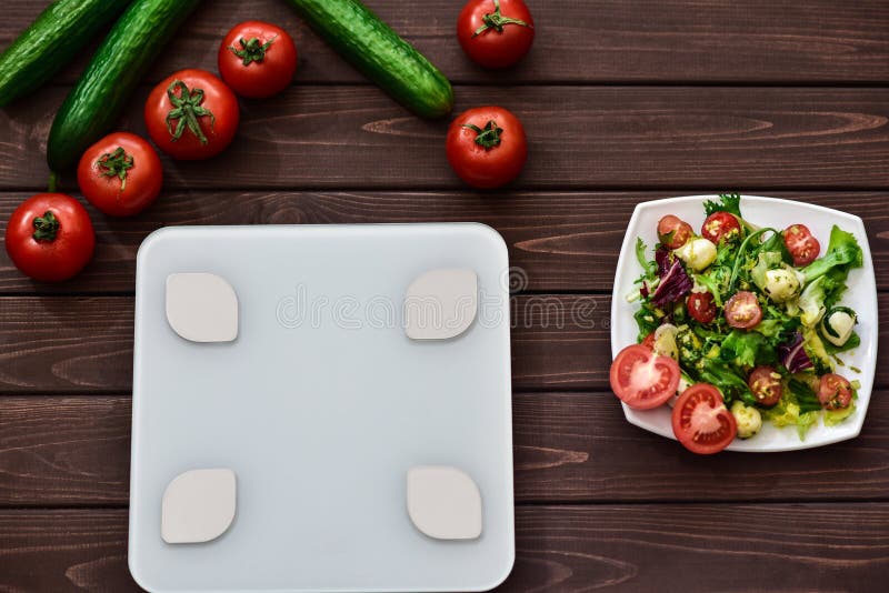 Het op dieet zijn en controlecalorie?n voor goed gezondheidsconcept Salade slimme gewichtsschalen veggies aan boord stock afbeelding Het op dieet zijn en controlecalorie?n voor goed gezondheidsconcept Salade slimme gewichtsschalen veggies aan boord stock afbeelding