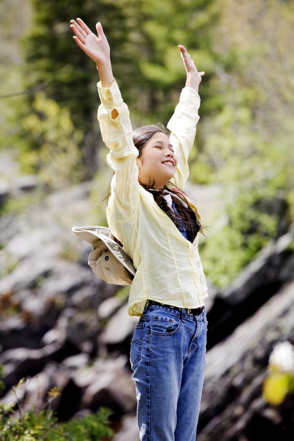 Girl raising hands in praise outdoors. Girl raising hands in praise outdoors