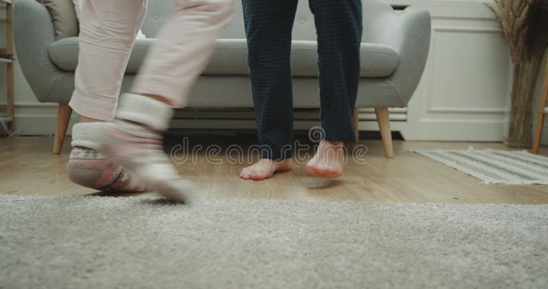 Het paar die van de huisstijl in de woonkamerclose-up dansen die benen vangen