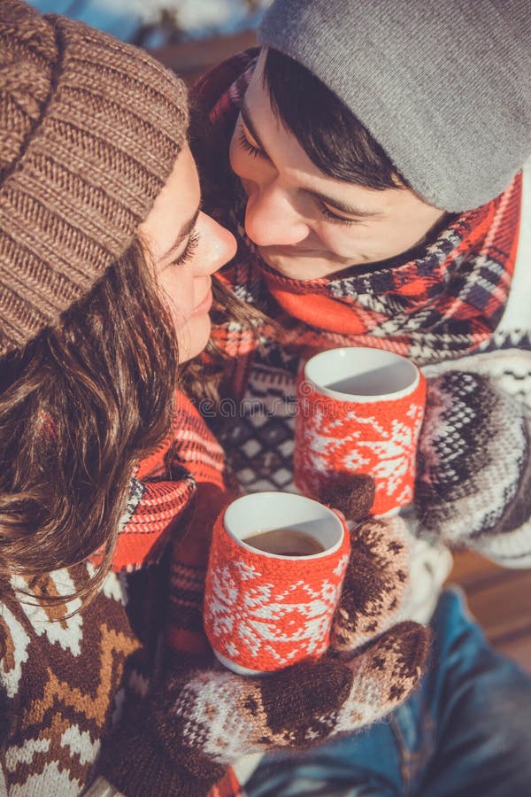 Young couple drinks hot tea in winter park. Young couple drinks hot tea in winter park