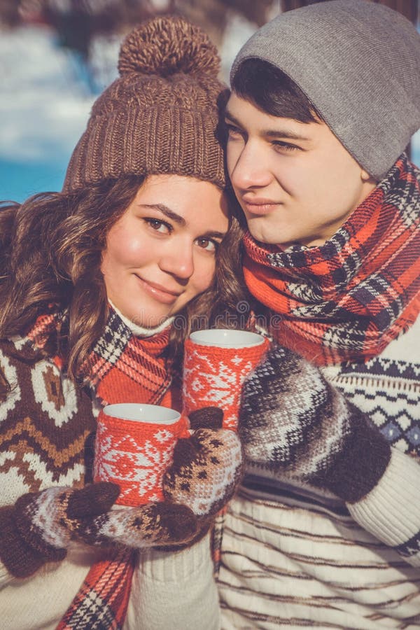 Young couple drinks hot tea in winter park. Young couple drinks hot tea in winter park