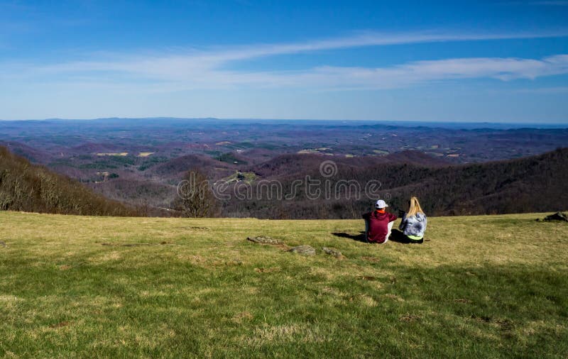 Floyd County, VA – March 31st: Couple enjoying the View from Rocky Knob on the Blue Ridge Parkway located in Floyd County, Virginia USA on March 31st, 2018. Floyd County, VA – March 31st: Couple enjoying the View from Rocky Knob on the Blue Ridge Parkway located in Floyd County, Virginia USA on March 31st, 2018.