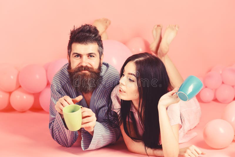 Het paar ontspant in ochtend met koffie Het paar in liefde drinkt koffie in bed Man en vrouw in binnenlandse kleren, pyjama's royalty-vrije stock afbeelding Het paar ontspant in ochtend met koffie Het paar in liefde drinkt koffie in bed Man en vrouw in binnenlandse kleren, pyjama's royalty-vrije stock afbeelding