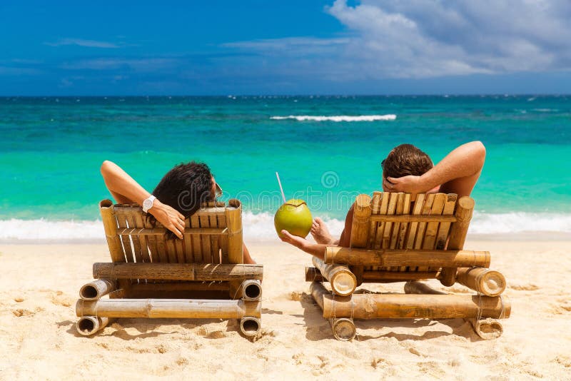 Het paar van de strandzomer op de vakantie van de eilandvakantie ontspant in de zon
