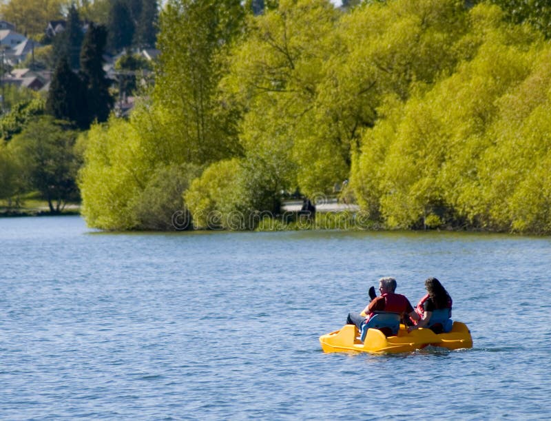 A couple in a paddle boat in a lake. A couple in a paddle boat in a lake.