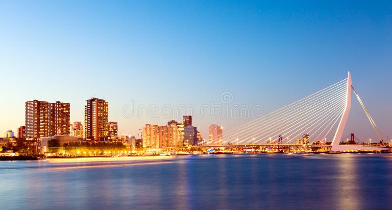 Het Panorama van Rotterdam Erasmus brug over de rivier Meuse met wolkenkrabbers in Rotterdam, Zuid-Holland, Nederland tijdens sch royalty-vrije stock foto Het Panorama van Rotterdam Erasmus brug over de rivier Meuse met wolkenkrabbers in Rotterdam, Zuid-Holland, Nederland tijdens sch royalty-vrije stock foto