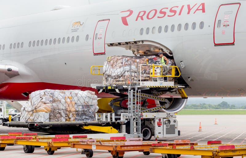 Het passagiersvliegtuig Boeing 777-300 van Rossiya-enkel gelande Luchtvaartlijnen, wordt lading leeggemaakt van de vliegtuigen royalty-vrije stock foto Het passagiersvliegtuig Boeing 777-300 van Rossiya-enkel gelande Luchtvaartlijnen, wordt lading leeggemaakt van de vliegtuigen royalty-vrije stock foto