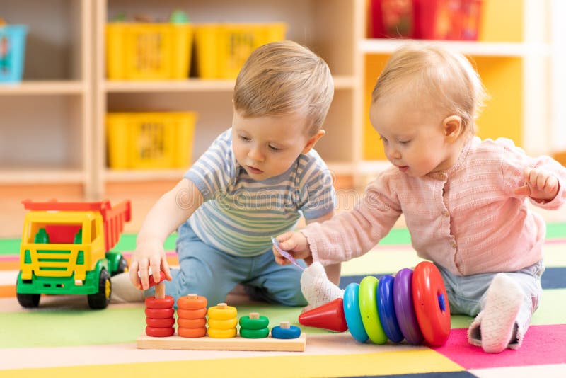 Het peuterjongen en meisjes spelen op vloer met onderwijsspeelgoed Kinderen thuis of opvang