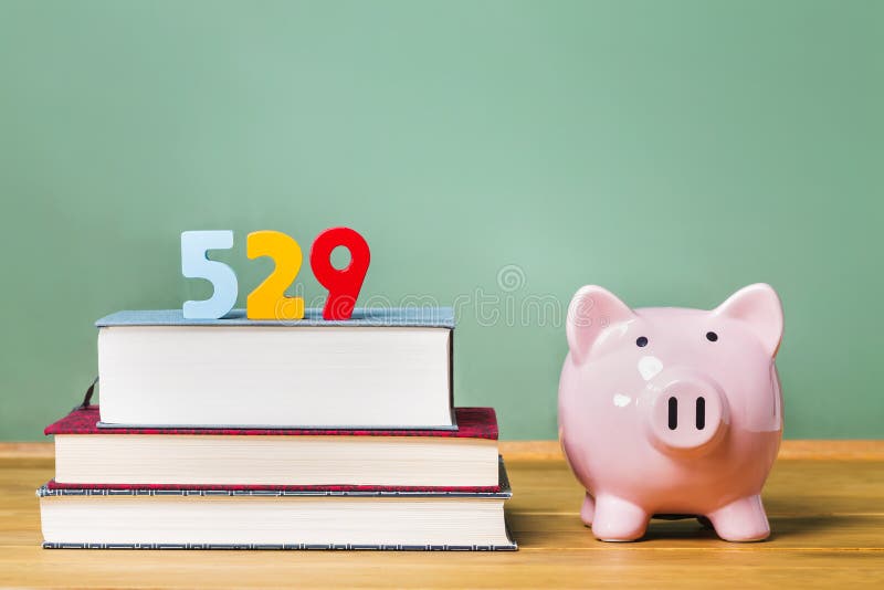 het planthema van 529 universiteitsbesparingen met handboeken en spaarvarken stock fotografie het planthema van 529 universiteitsbesparingen met handboeken en spaarvarken stock fotografie