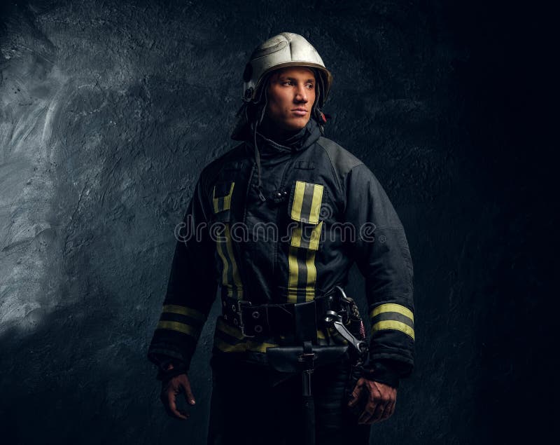 Het portret van brandbestrijder kleedde zich in eenvormige en veiligheidshelm zijdelings kijkend met een zekere blik