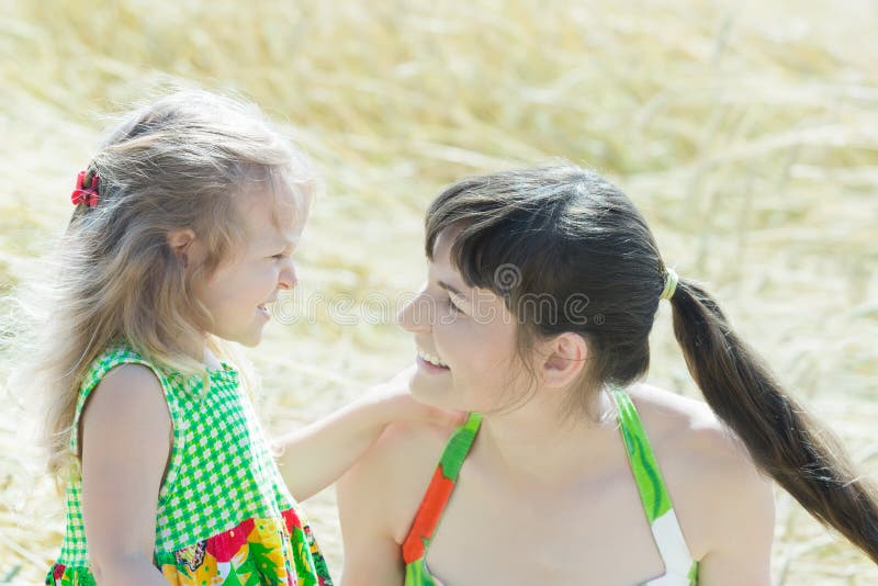 Het portret van de profielfamilie van vrolijke vrouw en haar weinig dochter face to face in openlucht stock afbeeldingen Het portret van de profielfamilie van vrolijke vrouw en haar weinig dochter face to face in openlucht stock afbeeldingen