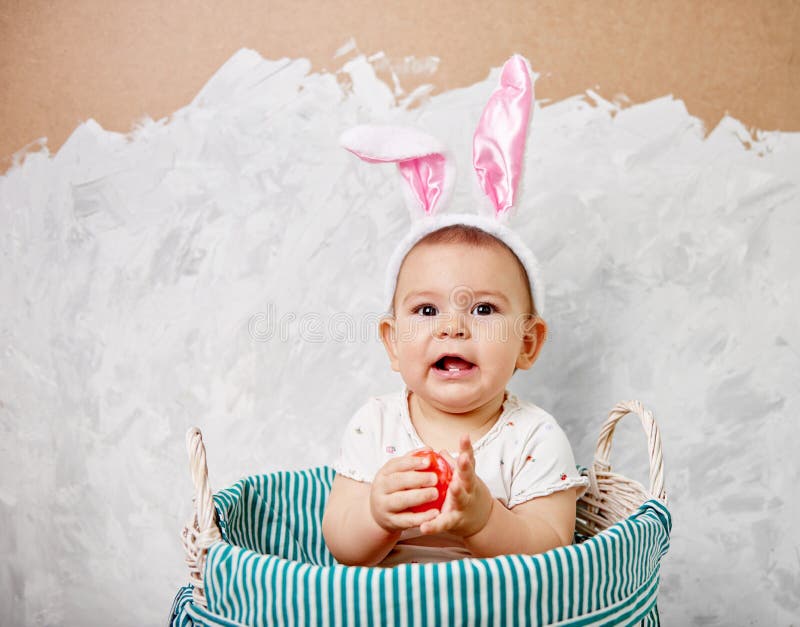 Het portret van een leuke baby gekleed in Paashaasoren in een mand houdt concept van ei het gelukkige Pasen royalty-vrije stock afbeelding Het portret van een leuke baby gekleed in Paashaasoren in een mand houdt concept van ei het gelukkige Pasen royalty-vrije stock afbeelding