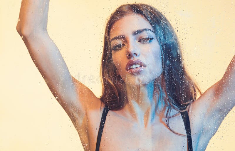 Het portret van een mooie droevige vrouw in regenachtig weer, het peinzende meisje kijken door het glazen venster met regen daalt stock afbeeldingen Het portret van een mooie droevige vrouw in regenachtig weer, het peinzende meisje kijken door het glazen venster met regen daalt stock afbeeldingen
