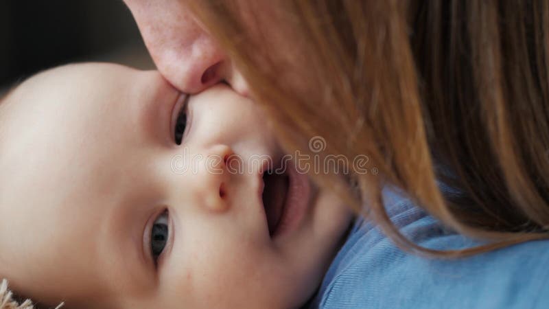 Het portret van een mooie vrouwen kussende baby, moeder kust dicht omhoog haar pasgeboren baby