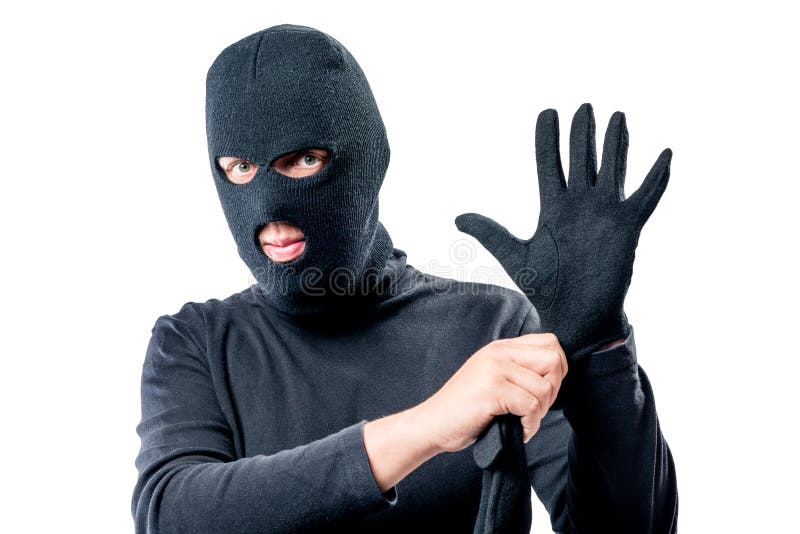 Het portret van een rover in een masker op zijn gezicht maakt een handschoen recht stock foto's Het portret van een rover in een masker op zijn gezicht maakt een handschoen recht stock foto's
