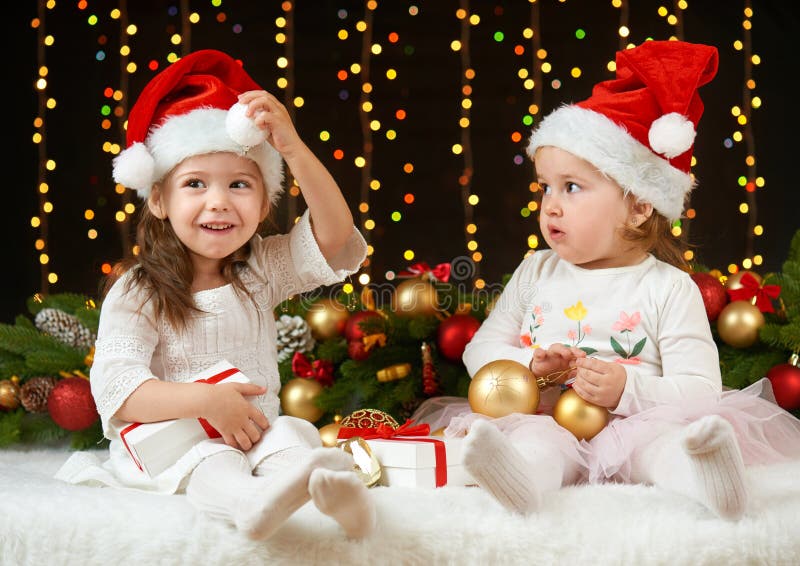 Het portret van het kindmeisje in Kerstmisdecoratie, gelukkige emoties, het concept van de de wintervakantie, donkere achtergrond stock fotografie Het portret van het kindmeisje in Kerstmisdecoratie, gelukkige emoties, het concept van de de wintervakantie, donkere achtergrond stock fotografie