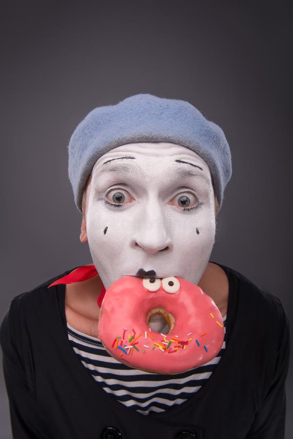 Het portret van knap mannetje bootst het eten van een smakelijk roze na royalty-vrije stock afbeeldingen Het portret van knap mannetje bootst het eten van een smakelijk roze na royalty-vrije stock afbeeldingen