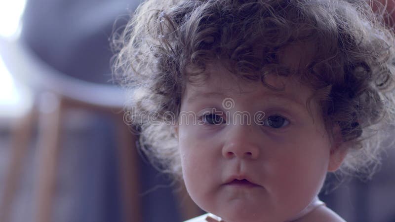 Het portret van krullend-haired kind unfocused achtergrond