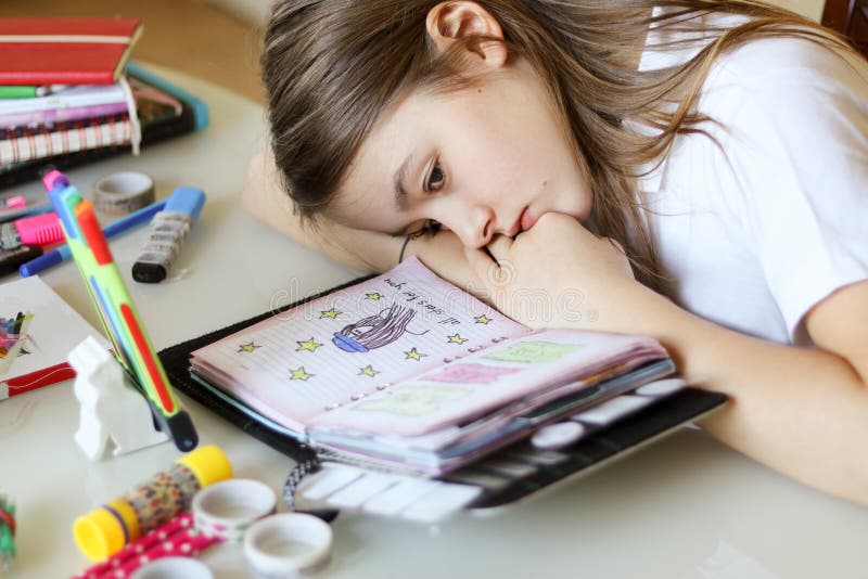 Het portret van mooi preteen meisjesdagdromen die met haar hoofd op handen liggen bekijkend haar romantische agenda royalty-vrije stock foto's Het portret van mooi preteen meisjesdagdromen die met haar hoofd op handen liggen bekijkend haar romantische agenda royalty-vrije stock foto's