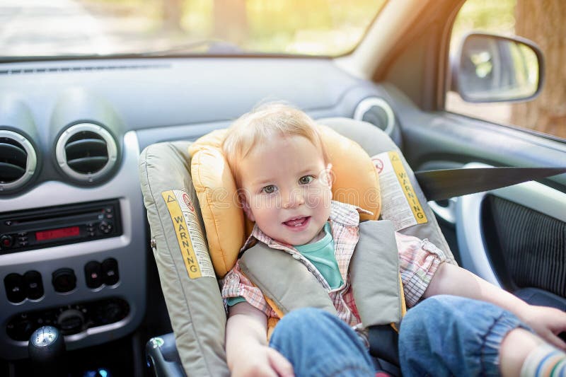 Het portret van mooie de jongenszitting van de 1 éénjarigepeuter in de zetel van de autoveiligheid zette in de voorzetel op De ve stock foto's Het portret van mooie de jongenszitting van de 1 éénjarigepeuter in de zetel van de autoveiligheid zette in de voorzetel op De ve stock foto's