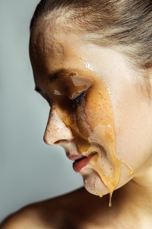 Het portret van het profiel zijaanzicht van mooie jonge donkerbruine vrouw met sproeten en honing op gezicht met gesloten ogen en stock fotografie Het portret van het profiel zijaanzicht van mooie jonge donkerbruine vrouw met sproeten en honing op gezicht met gesloten ogen en stock fotografie