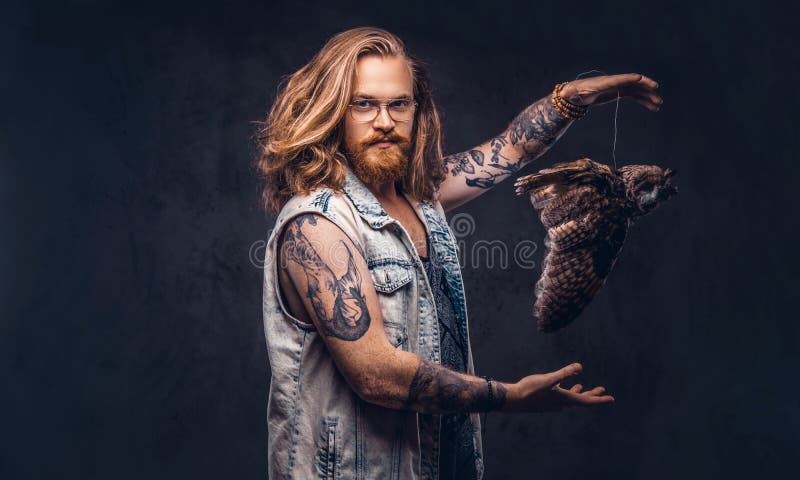 Het portret van a tattoed roodharige hipster mannetje met lang luxuriant haar en de volledige baard kleedde zich in een t-shirt e royalty-vrije stock foto's Het portret van a tattoed roodharige hipster mannetje met lang luxuriant haar en de volledige baard kleedde zich in een t-shirt e royalty-vrije stock foto's