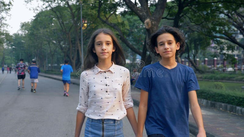 Het portret van tieners, jongen en het meisje die in aard in een groot park met genoegen, broer en zustertweelingen de lopen lope stock afbeeldingen Het portret van tieners, jongen en het meisje die in aard in een groot park met genoegen, broer en zustertweelingen de lopen lope stock afbeeldingen