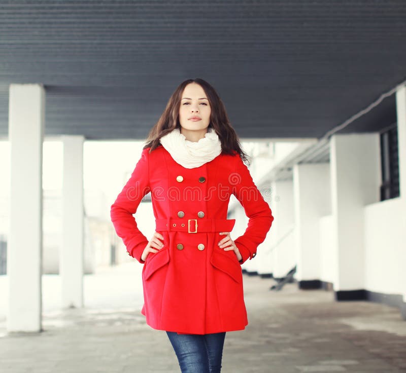 Het portret van vrij jonge vrouw kleedde in openlucht een rode laag stock foto Het portret van vrij jonge vrouw kleedde in openlucht een rode laag stock foto