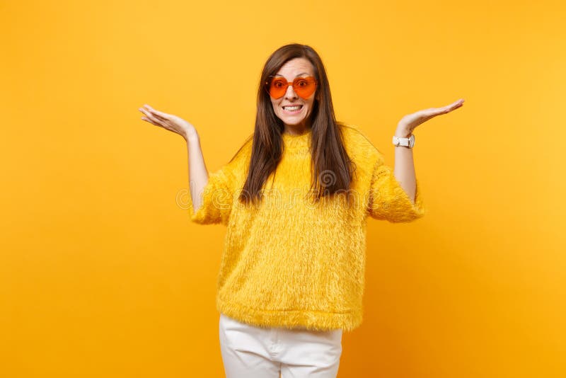 Het portret van vrij schuldig jong meisje die in van het de broekhart van de bontsweater de witte oranje glazen handen uitspreide stock fotografie Het portret van vrij schuldig jong meisje die in van het de broekhart van de bontsweater de witte oranje glazen handen uitspreide stock fotografie
