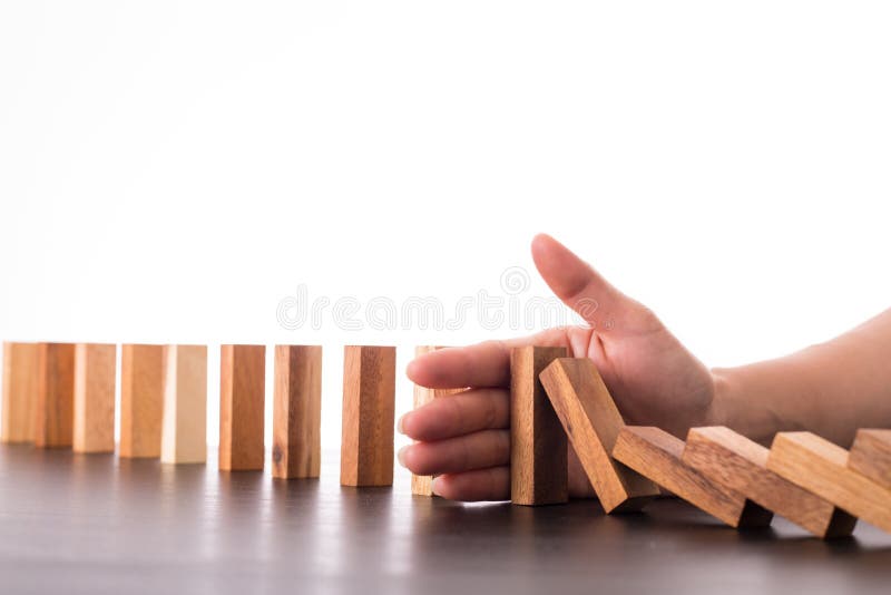 Het risicoeffect van de eindedomino, zakenman die hand voor beheer s gebruiken stock afbeelding Het risicoeffect van de eindedomino, zakenman die hand voor beheer s gebruiken stock afbeelding
