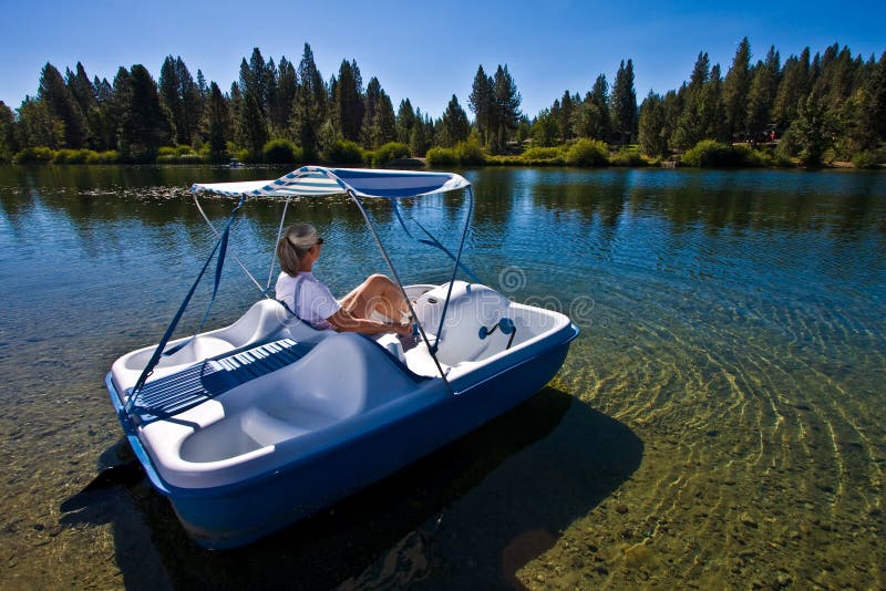 Senior woman in paddle boat on pond. Senior woman in paddle boat on pond