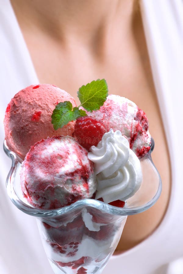 Fruit ice-cream in glass, in background young woman decolte, closeup. Fruit ice-cream in glass, in background young woman decolte, closeup