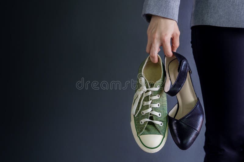 Work life balance concept, present by business working woman holding a high heal and sneaker shoes, croped image with copy space. Work life balance concept, present by business working woman holding a high heal and sneaker shoes, croped image with copy space