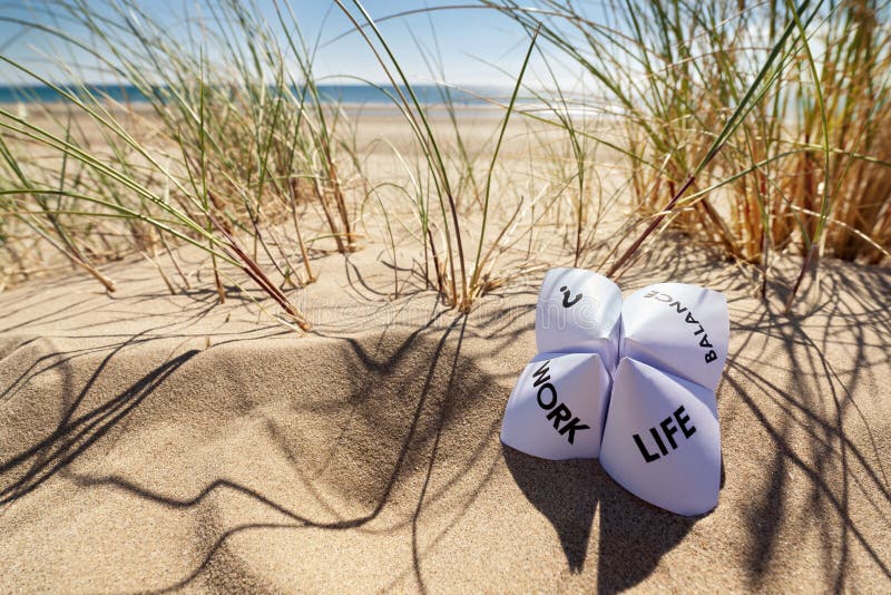 Origami fortune teller on vacation at the beach concept for work life balance choices. Origami fortune teller on vacation at the beach concept for work life balance choices