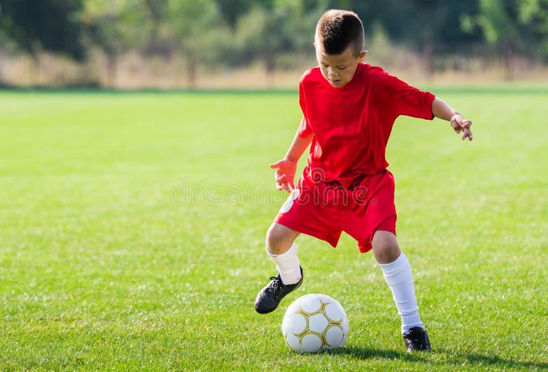 Het schoppen van de jongen voetbalbal stock afbeeldingen Het schoppen van de jongen voetbalbal stock afbeeldingen