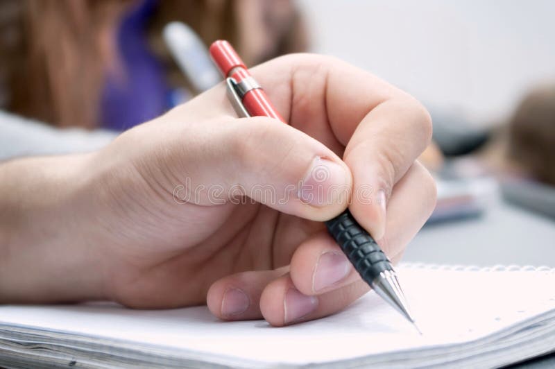 Left hand holding a pen, writing document. Left hand holding a pen, writing document