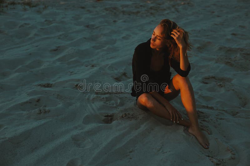 Het sexy blonde haired jonge vrouw stellen in zand van woestijn dat door rood plaatsend zonlicht wordt aangestoken stock foto's Het sexy blonde haired jonge vrouw stellen in zand van woestijn dat door rood plaatsend zonlicht wordt aangestoken stock foto's