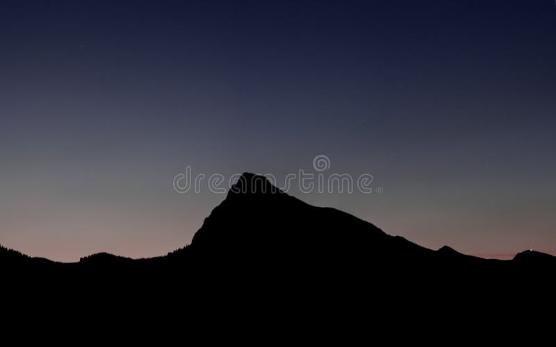 Het silhouet van het berglandschap onder een recente avondhemel na zonsondergang royalty-vrije stock foto Het silhouet van het berglandschap onder een recente avondhemel na zonsondergang royalty-vrije stock foto
